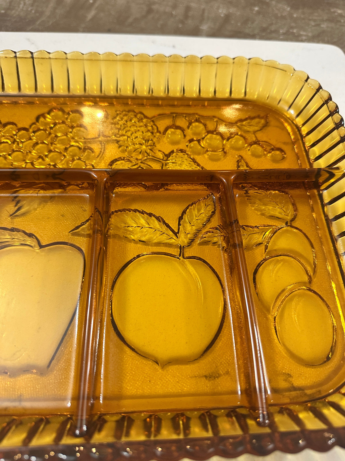 The Collected Chapter vintage Indiana Glass golden amber 5-part relish tray with embossed fruit and scalloped edges.