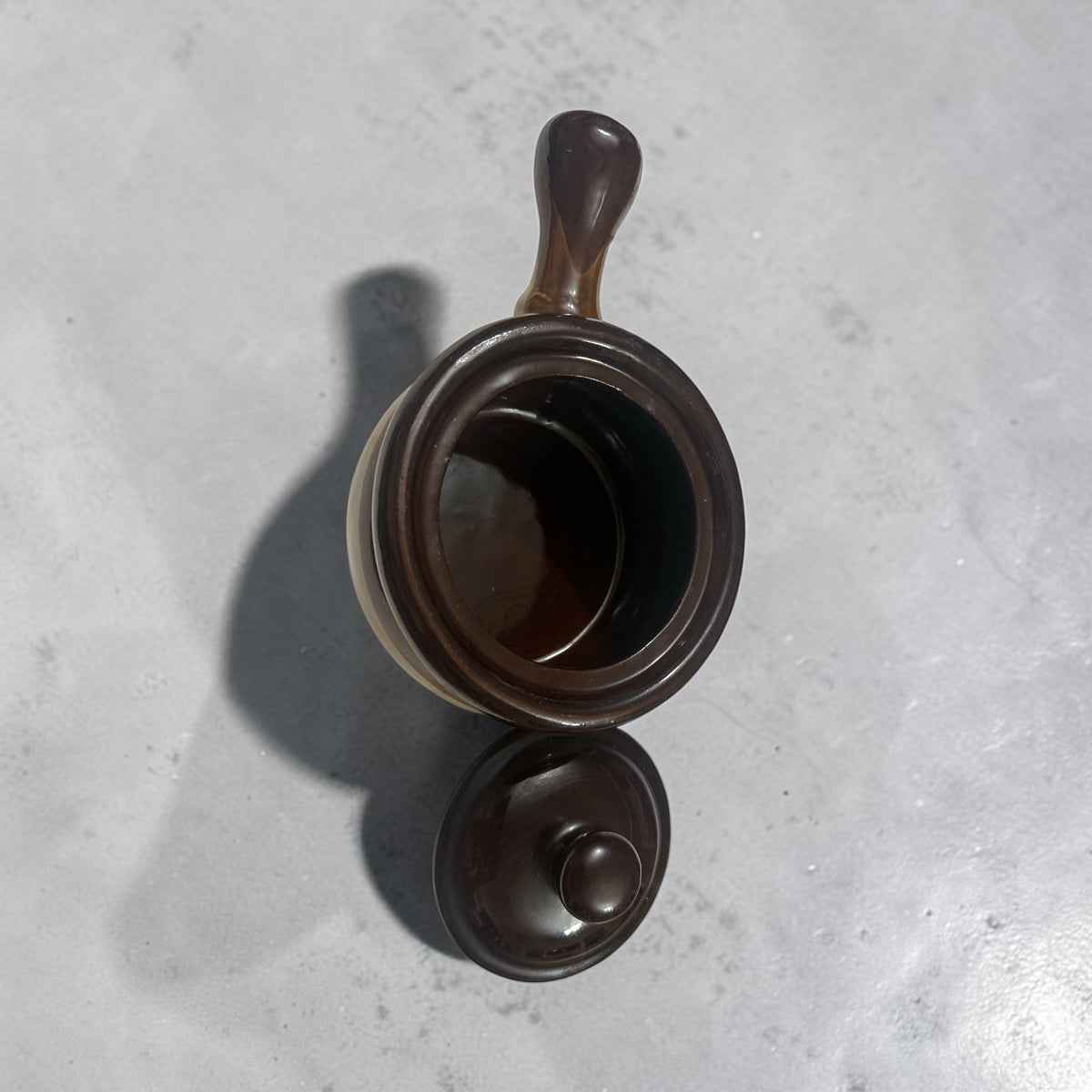 The Collected Chapter vintage brown and cream stoneware crock with lid and handle viewed from above
