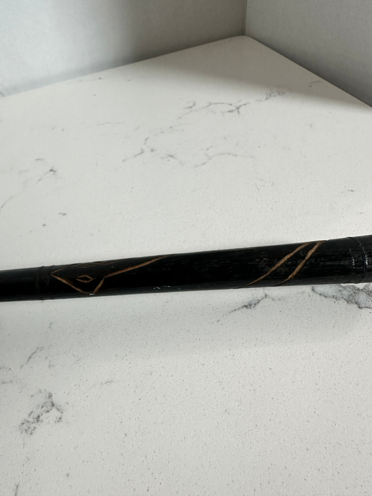 The Collected Chapter vintage handcrafted drum handle featuring dark wood with intricate carved geometric patterns.