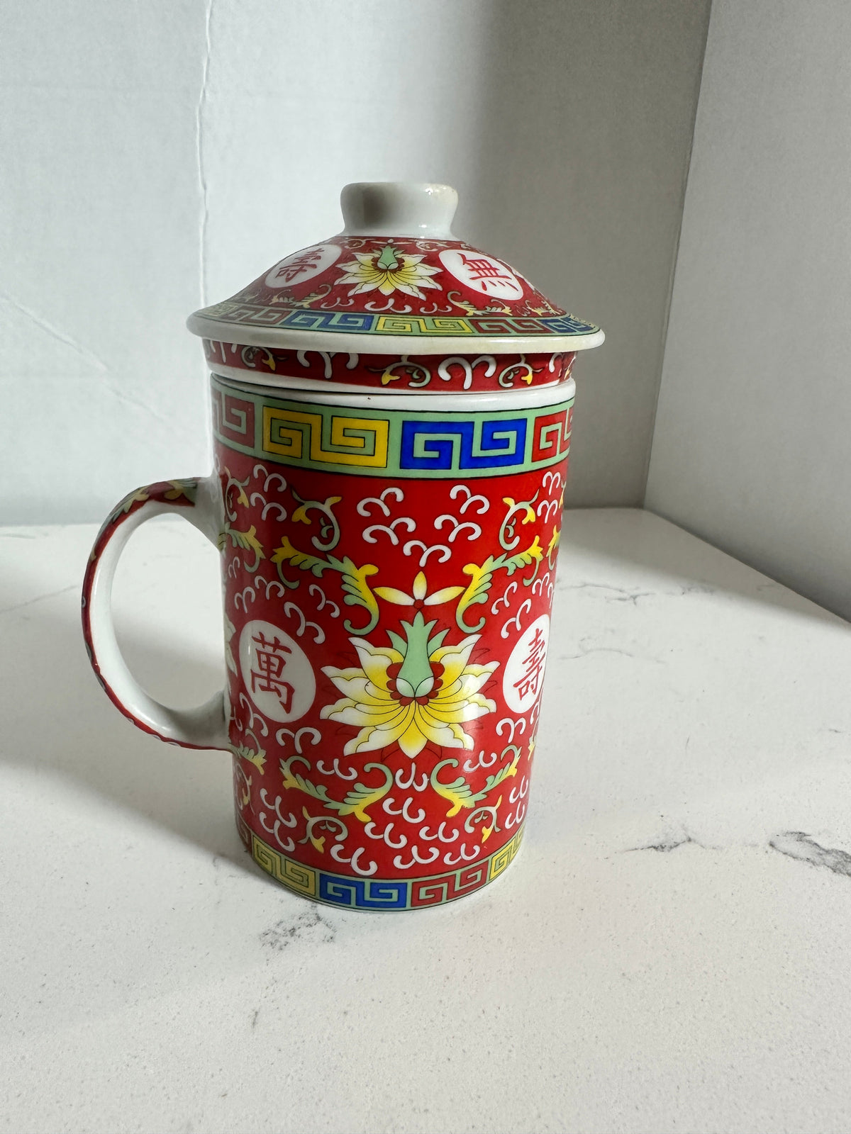 The Collected Chapter vintage Chinese Mun Shou porcelain tea mug with lid and infuser in vibrant red floral pattern.