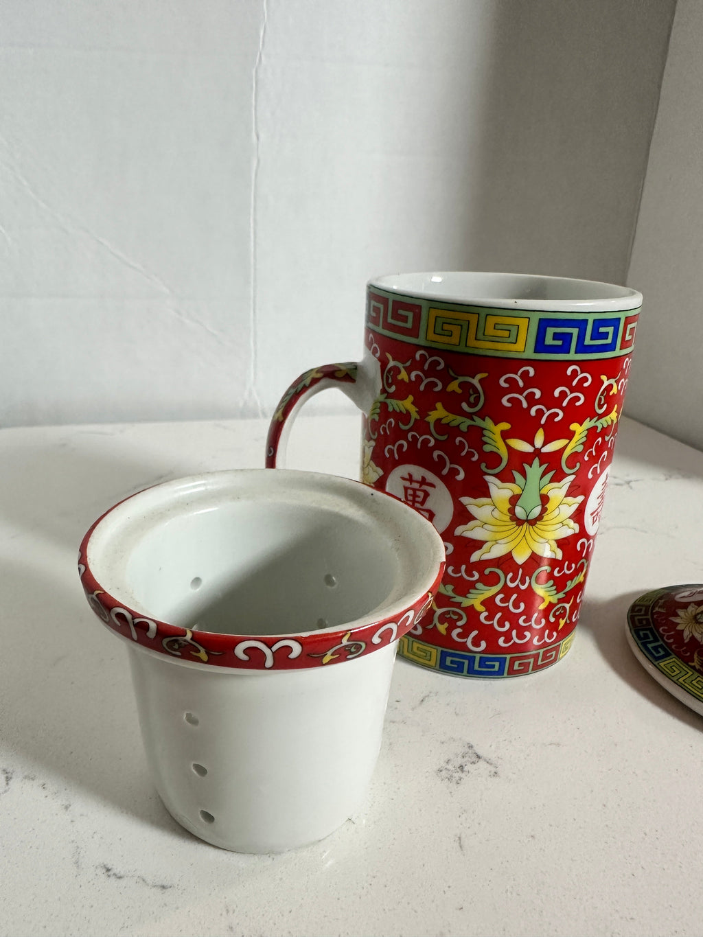 The Collected Chapter vintage Chinese Mun Shou porcelain tea mug with red floral pattern, infuser, and matching lid.