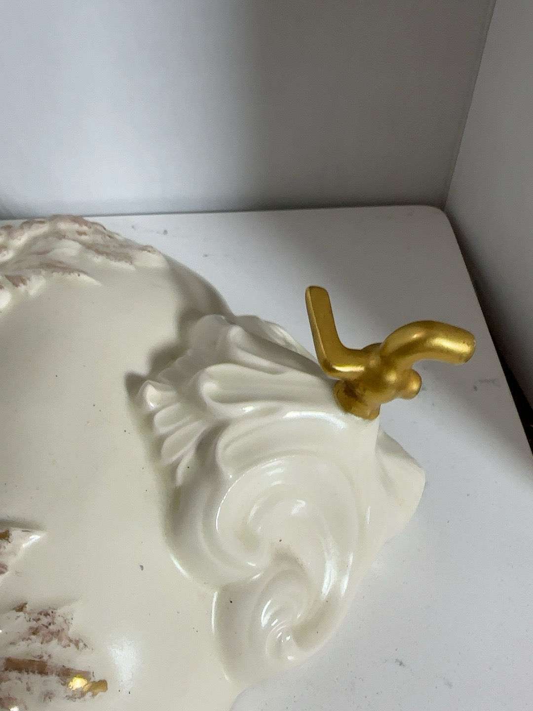 The Collected Chapter vintage resin wall dispenser in cream with ornate gold scrollwork and grape vine detailing.