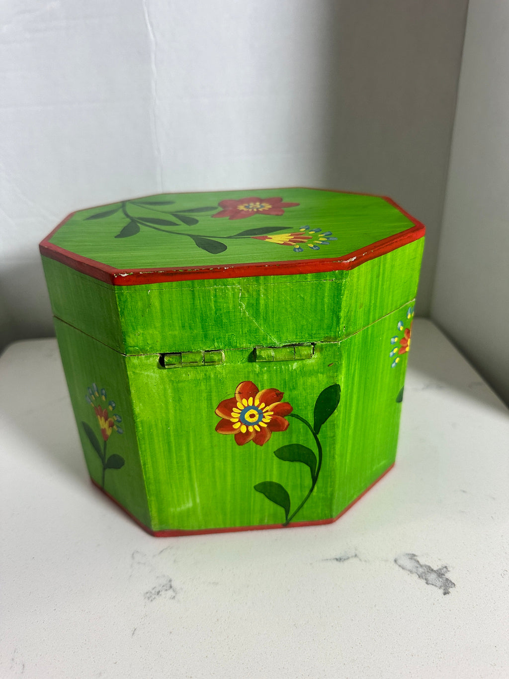 The Collected Chapter vintage octagonal wooden keepsake box in lime green with hand-painted folk art floral motifs.