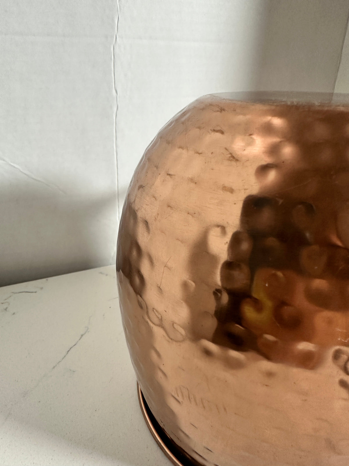 Close-up of The Collected Chapter hammered copper-tone tankard showing textured metal surface and warm metallic finish