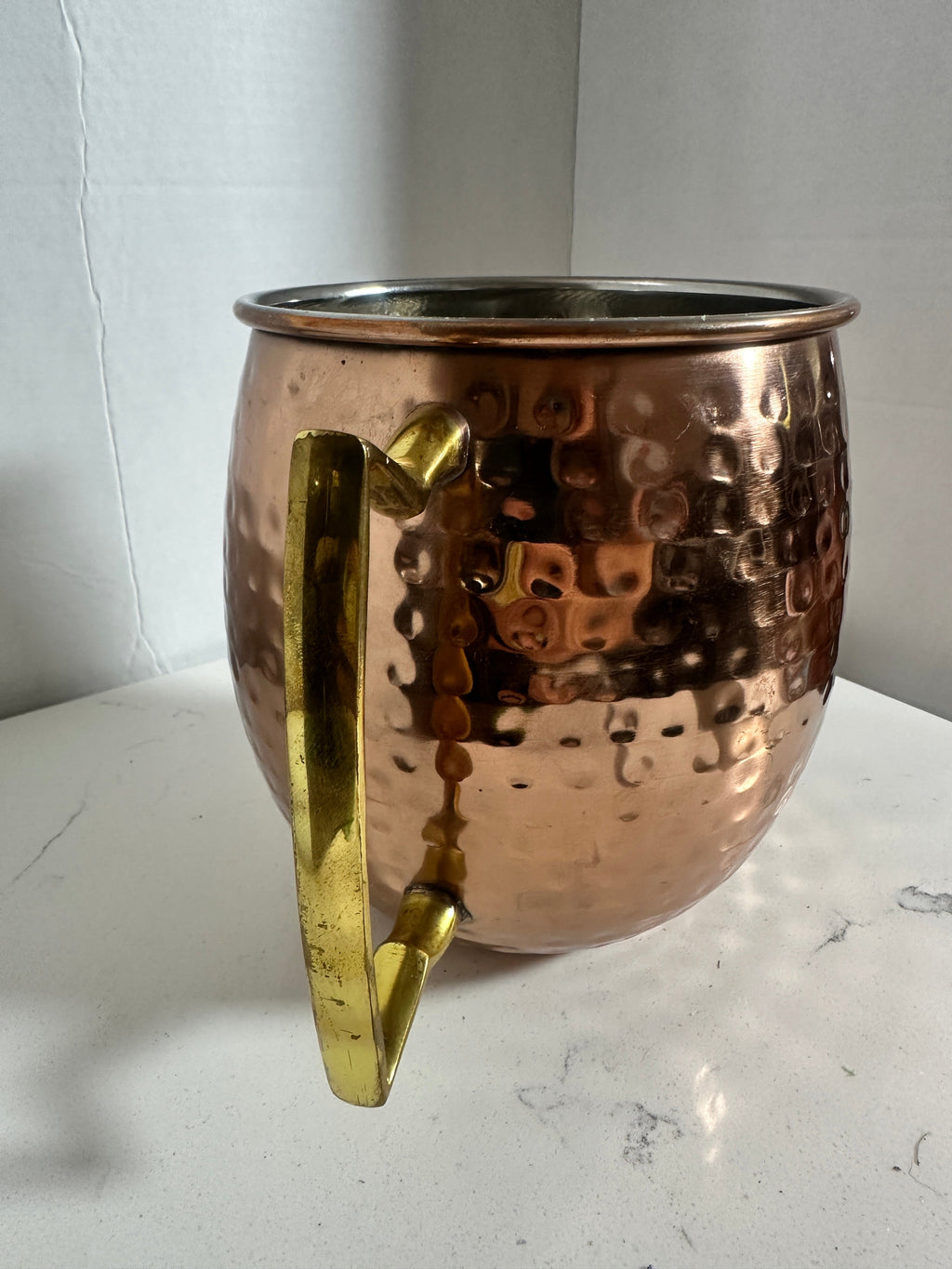 The Collected Chapter oversized hammered copper-tone tankard with a brass-tone handle and stainless-steel interior.