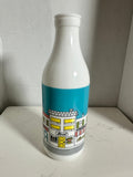 The Collected Chapter vintage white milk glass bottle vase featuring a colorful illustrated street scene graphic.