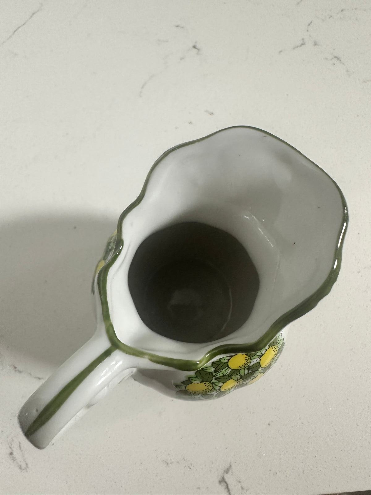 The Collected Chapter vintage miniature porcelain pitcher with a lemon motif and green scalloped rim, top-down view.