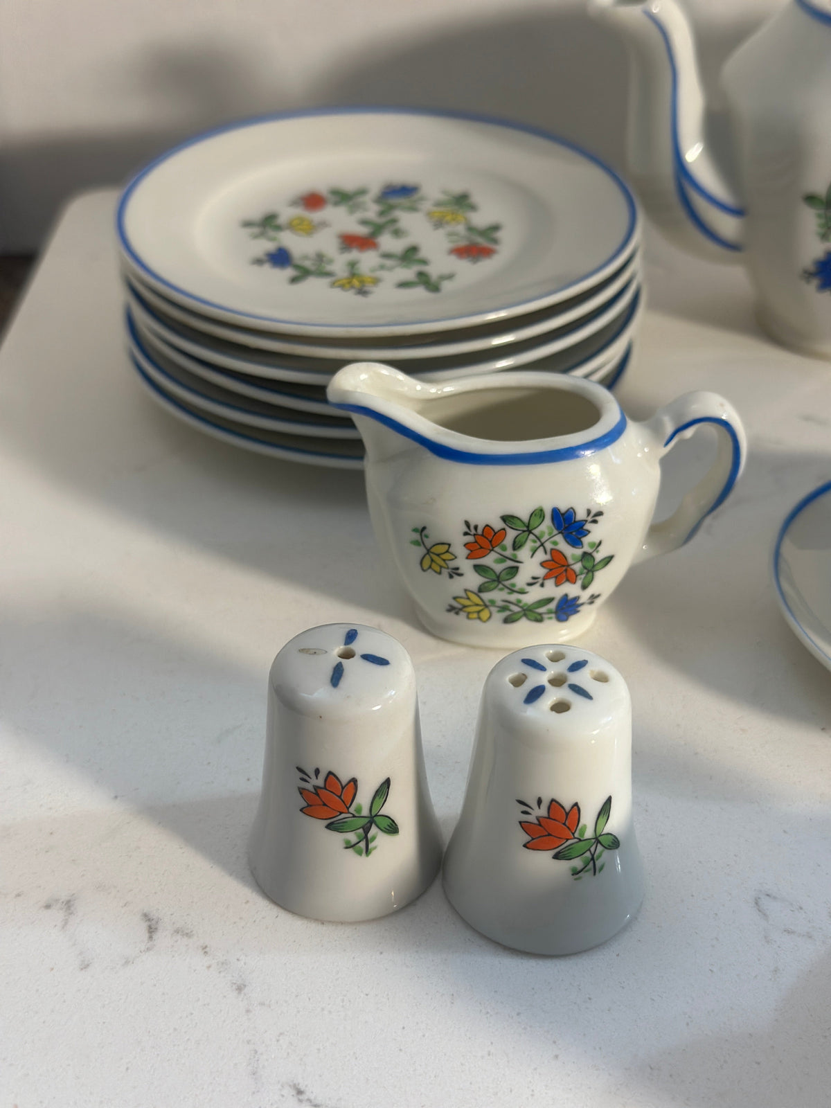 The Collected Chapter vintage miniature porcelain tea set with floral pattern, creamer, and salt and pepper shakers.