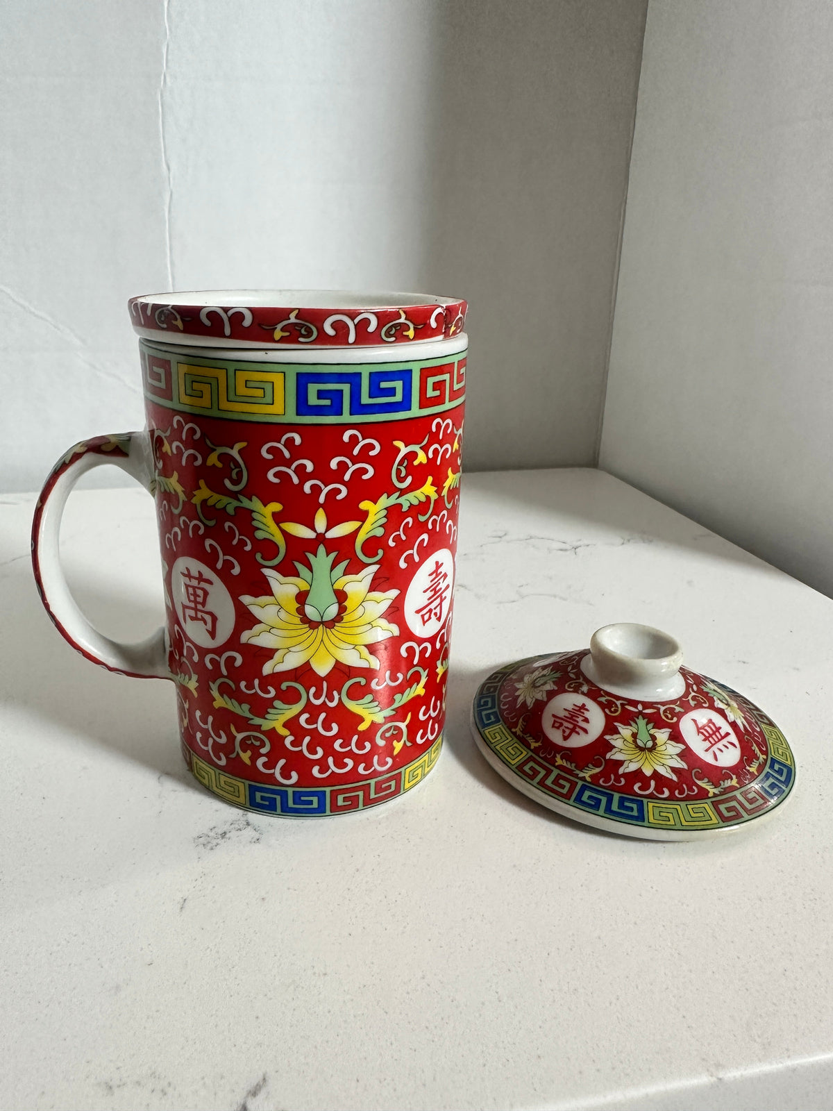 The Collected Chapter vintage Chinese Mun Shou porcelain tea mug with red floral pattern, infuser, and matching lid.