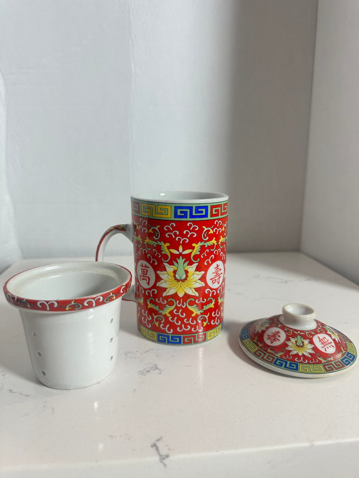 The Collected Chapter vintage Chinese Mun Shou porcelain tea mug with lid and infuser in vibrant red floral pattern.