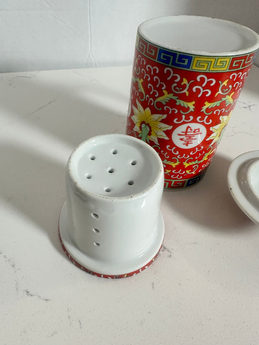 The Collected Chapter vintage Chinese Mun Shou porcelain tea mug with red floral pattern, infuser, and matching lid.