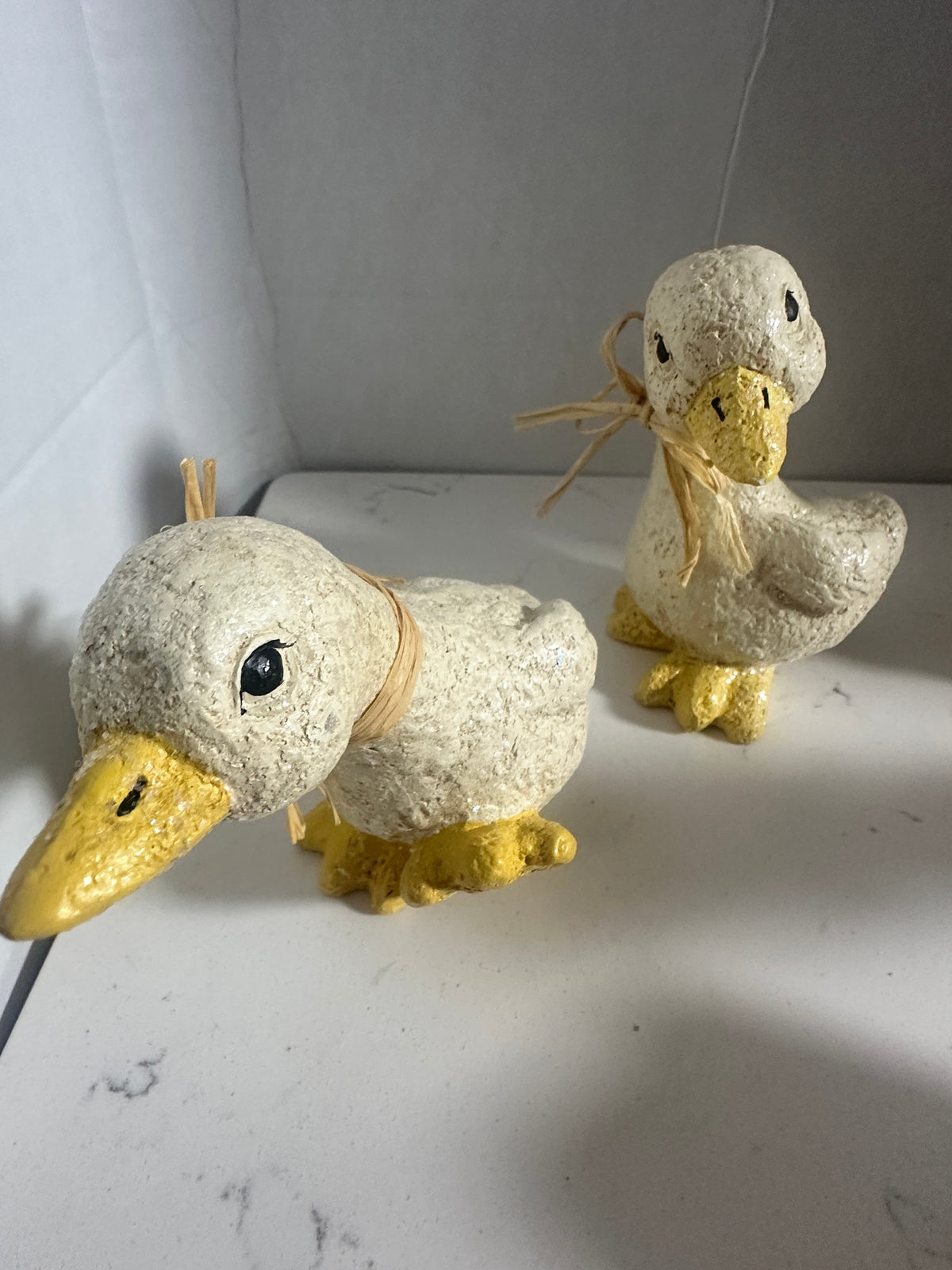 The Collected Chapter rustic cream and yellow duck figurines with raffia neck ties and textured glittery finish
