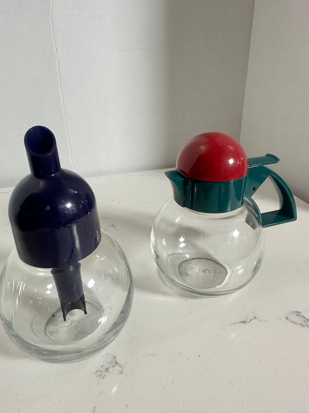 The Collected Chapter vintage STOHA Germany glass condiment set with a blue dispenser and a teal and red lidded jar.
