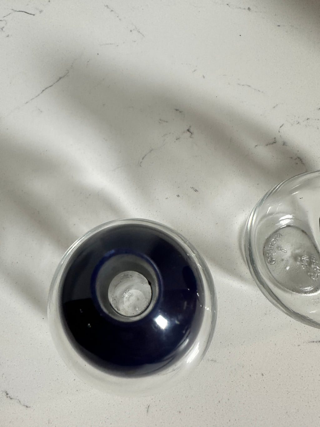 The Collected Chapter vintage STOHA Germany glass condiment set with a deep blue plastic dispenser top on white marble