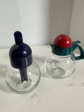 The Collected Chapter vintage STOHA Germany glass condiment set with colorful teal, red, and blue plastic lids.
