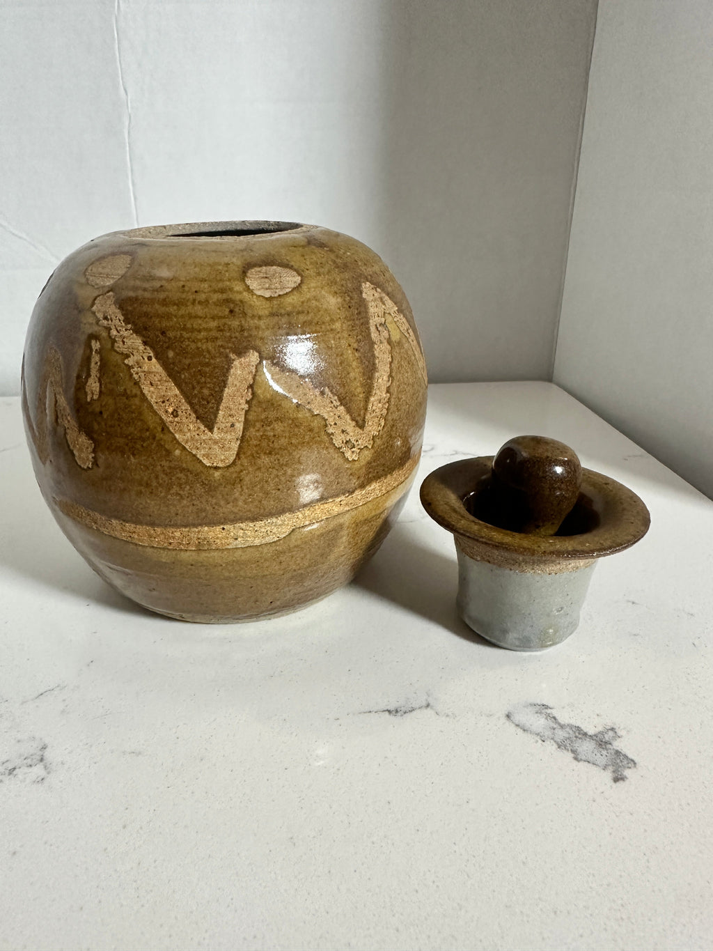The Collected Chapter vintage stoneware lidded jar with brown and tan abstract glaze and hand-thrown organic form.