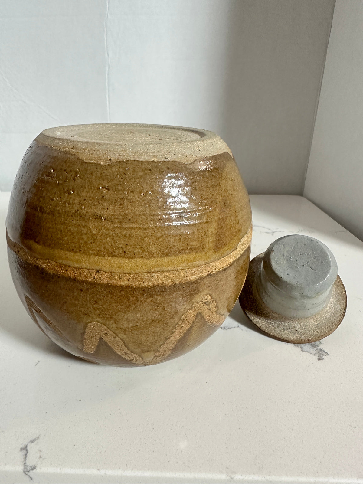The Collected Chapter vintage handmade stoneware lidded jar with brown and tan abstract glaze and rustic studio design.