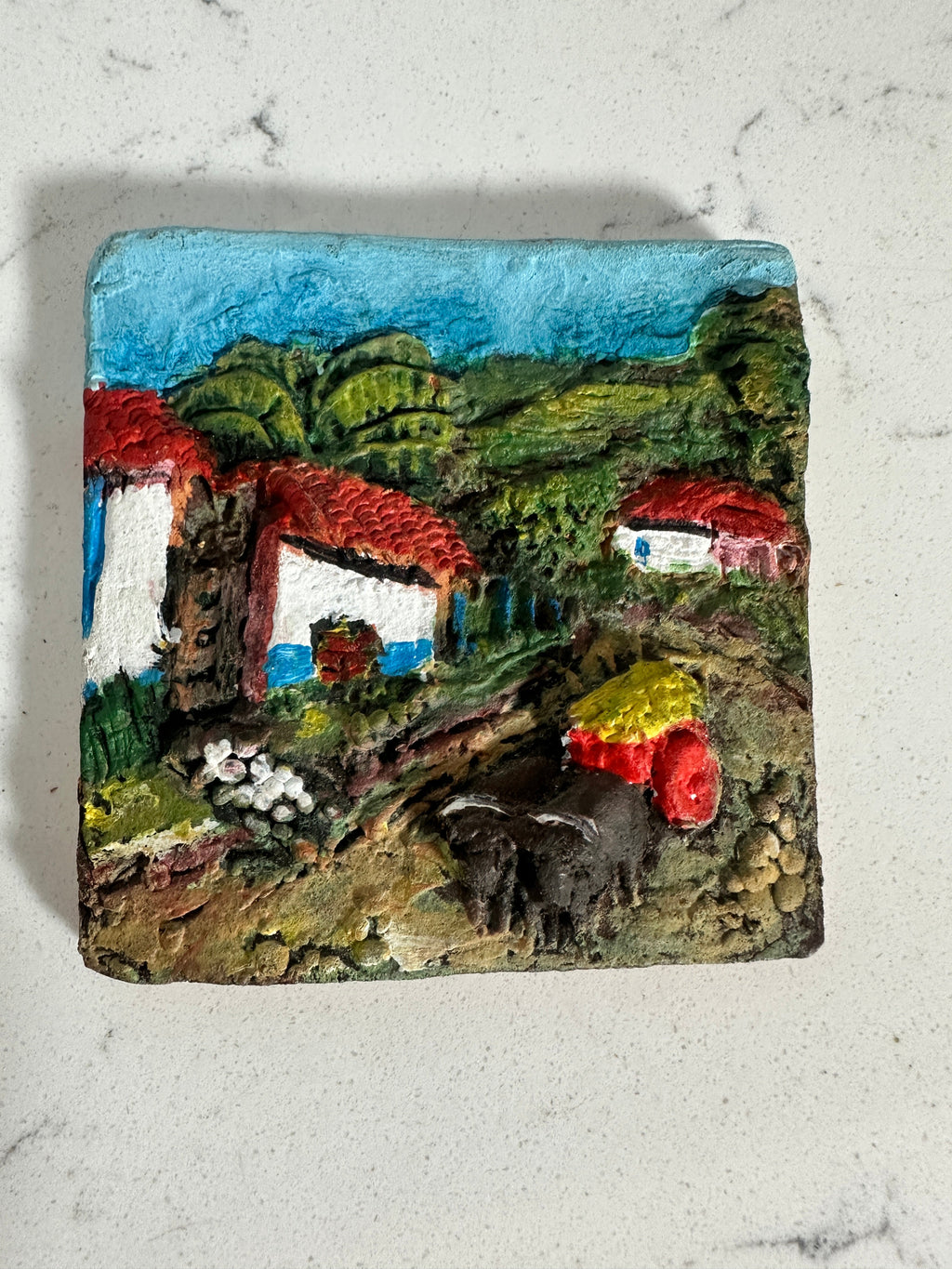 The Collected Chapter vintage Costa Rica ceramic relief wall plaque featuring a colorful hand-painted village scene.