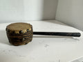 The Collected Chapter vintage handcrafted drum with natural hide head, leather-wrapped body, and long carved handle.
