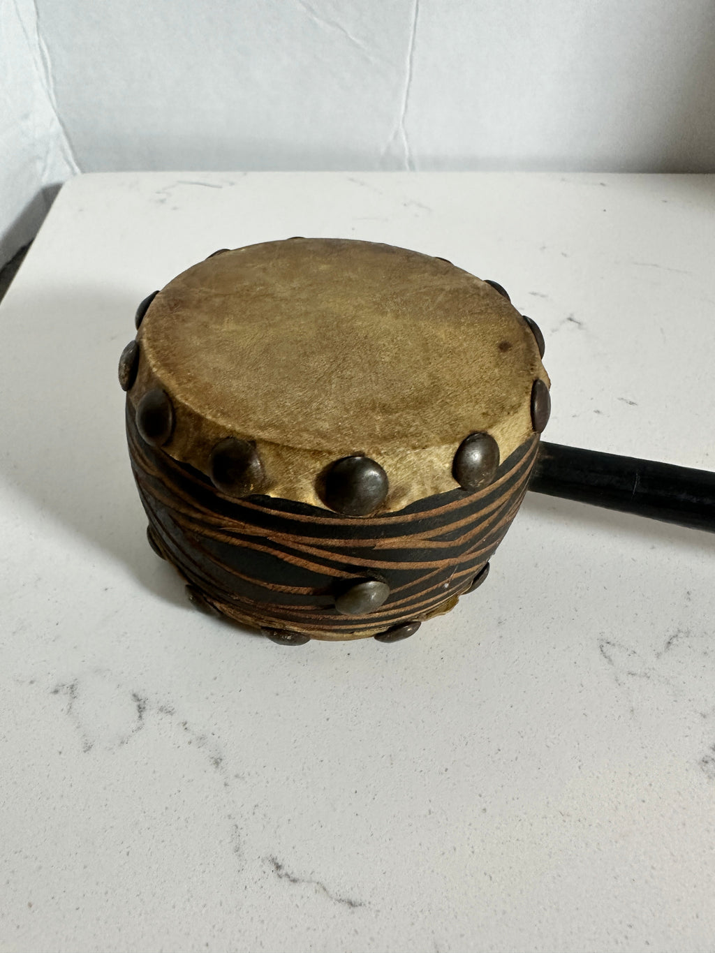 The Collected Chapter vintage handcrafted drum with natural hide head, leather-wrapped body, and aged metal stud accents.