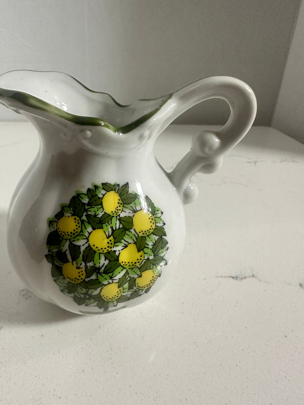 The Collected Chapter vintage miniature porcelain pitcher with a lemon motif and green scalloped rim.