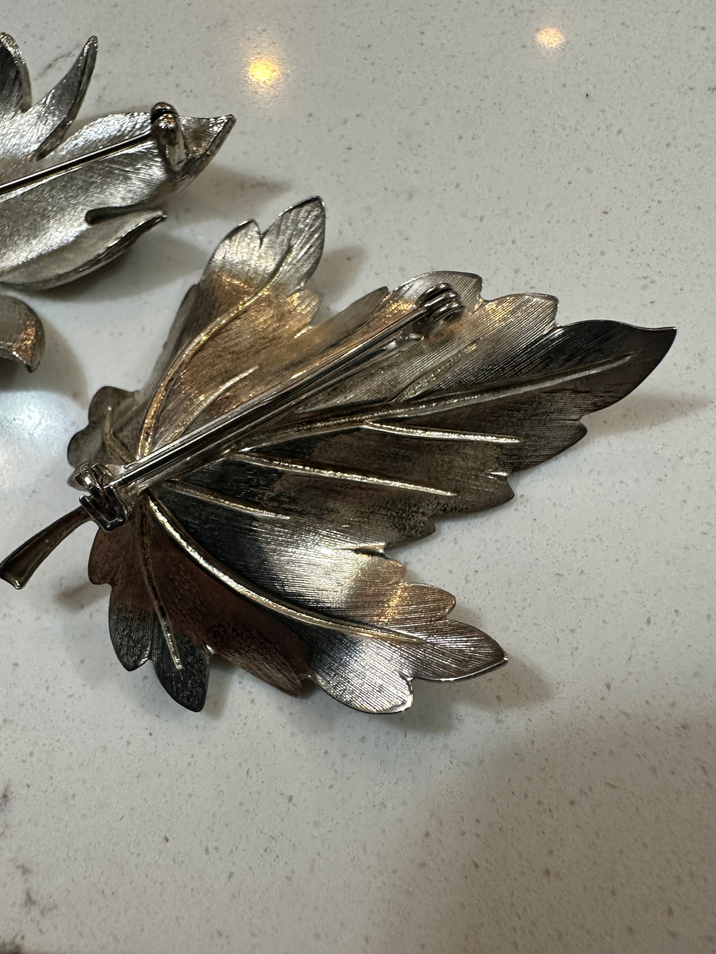 The Collected Chapter vintage silver-tone leaf brooches featuring textured metal surfaces and pin-back closures.