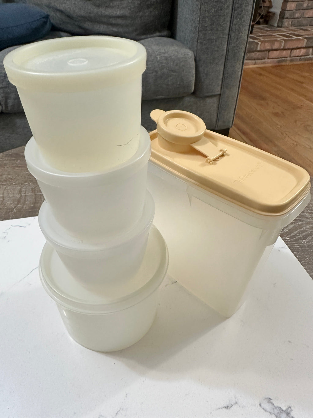 The Collected Chapter vintage Tupperware lot with cream round containers and a rectangular almond flip-top canister.