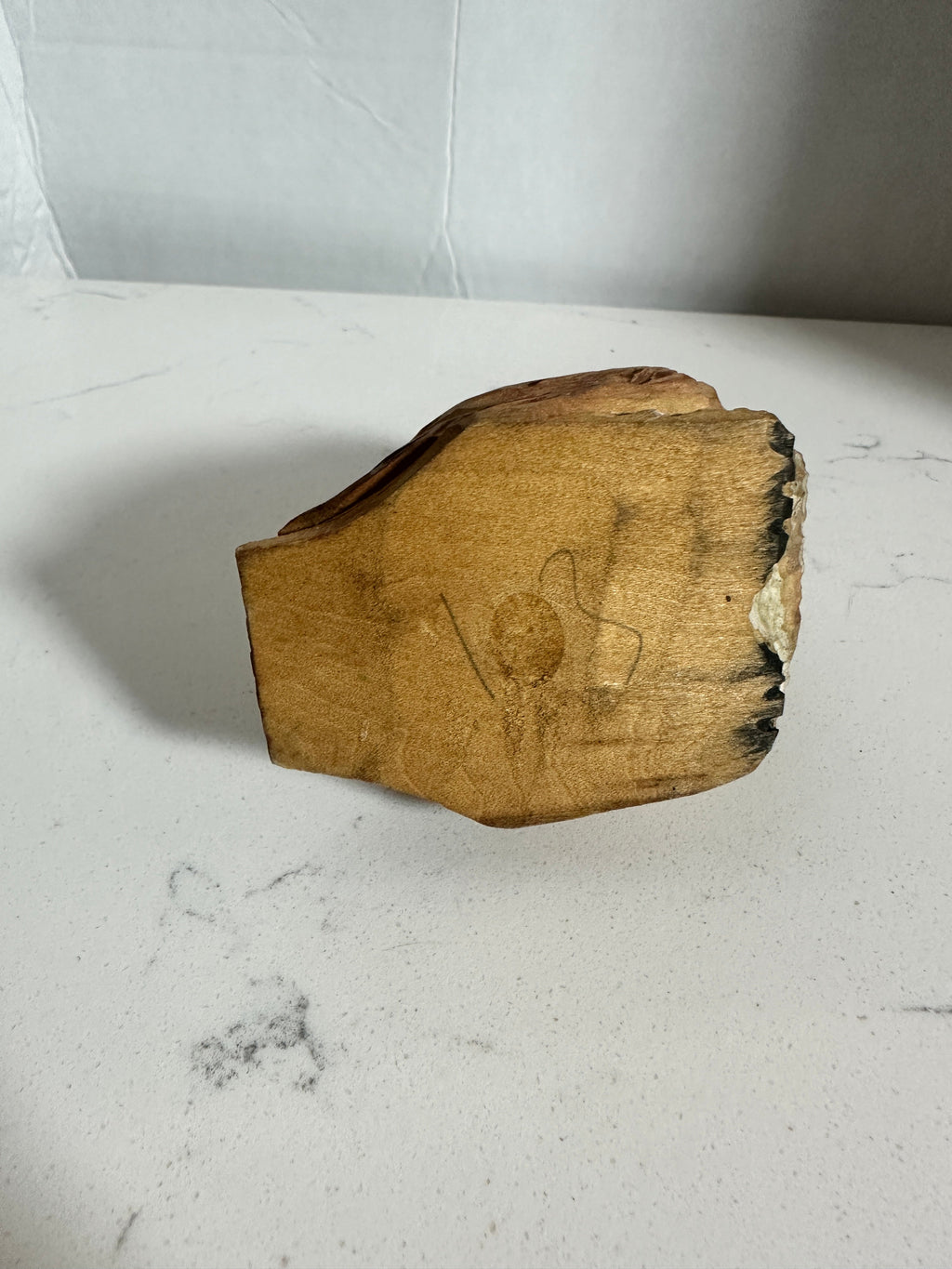 The Collected Chapter vintage hand-carved wooden owl figurine showing the underside with handwritten markings